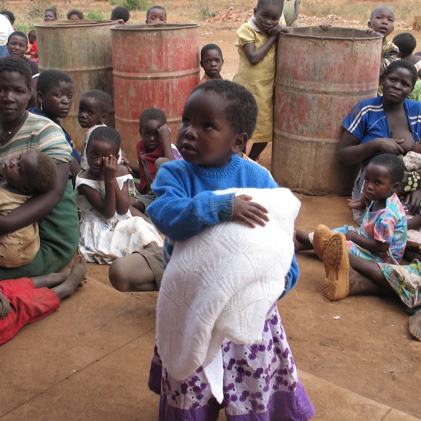 Chinthowa child receiving a blanket and jumper